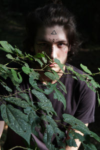 Close-up of young man against plants