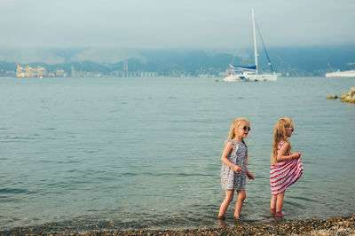 People on shore against sea