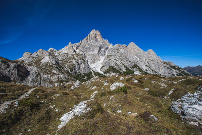 Scenic view of rocky mountains against blue sky