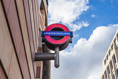 Iconic london underground sign mounted on urban building. london, uk, 29 march 2024