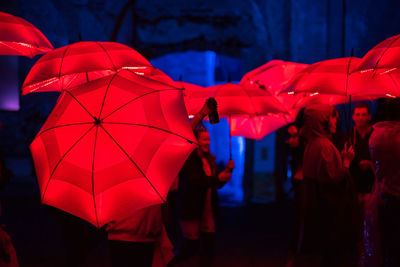 People with umbrella walking at night