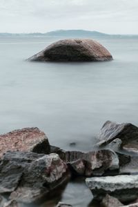 Rock formation on beach against sky