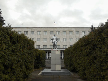 Statue amidst trees and building against sky