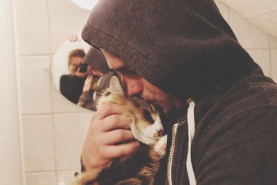 Close-up of man kissing cat at home