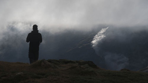 Rear view of man standing on mountain