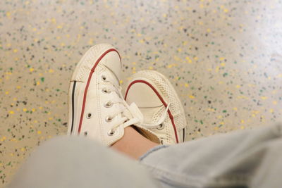 Low section of person wearing shoes on bed