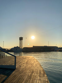 Pier on footpath against sky during sunset