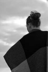Rear view of woman wrapped in blanket standing against sky