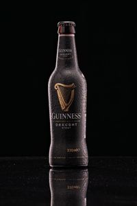 Close-up of wine glass bottle on table against black background