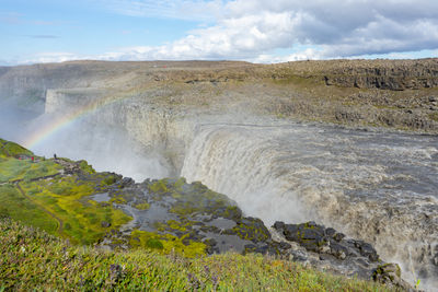 Scenic view of waterfall against sky