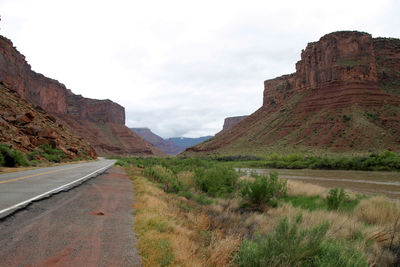 Road leading towards mountains against sky
