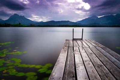 Wooden pier over lake against sky