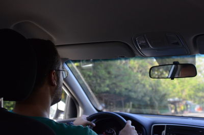 Rear view of man driving car