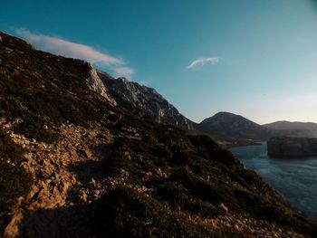 Scenic view of sea and mountains against sky