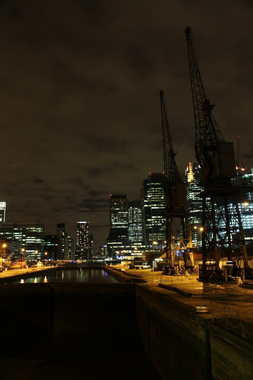 illuminated, building exterior, architecture, built structure, night, city, crane - construction machinery, sky, development, crane, construction site, industry, dusk, transportation, commercial dock, street light, outdoors, city life, construction, cloud - sky