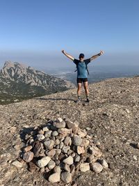 Full length of man standing on rocks against sky