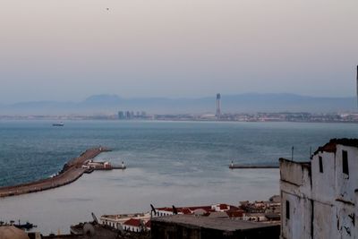 High angle view of buildings by sea against sky