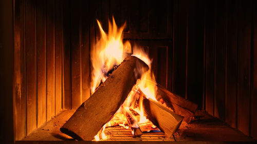 Close-up of fire burning at night in stylish indoor fireplace