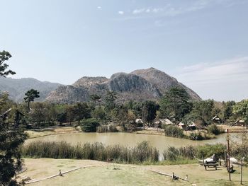 Scenic view of lake by mountains against sky