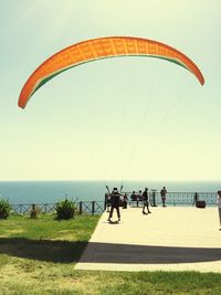 People on beach against clear sky