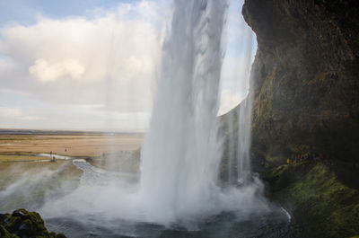 Scenic view of waterfall against sky