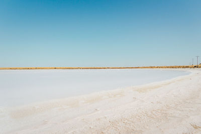 Scenic view of beach against clear blue sky