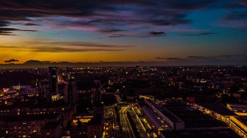 High angle view of illuminated city against sky at sunset