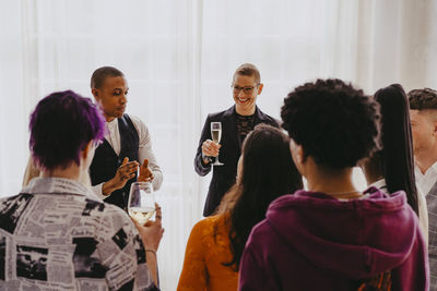 Smiling businesswoman enjoying drink with colleagues during event at convention center