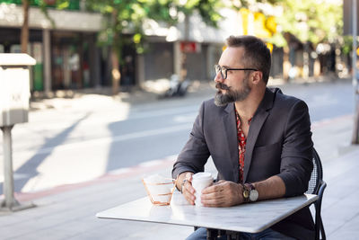 Happy middle age businessman portrait drinking a coffee outdoors in bangkok, thailand. person