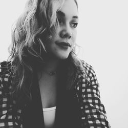 Close-up of thoughtful young woman looking away over white background