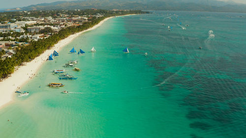 Travel concept sandy tropical beach with hotels and tourists near the blue lagoon