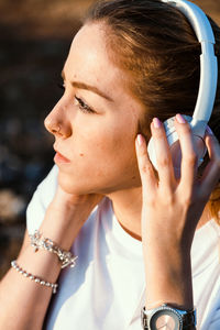 Woman looking away while listening through headphones