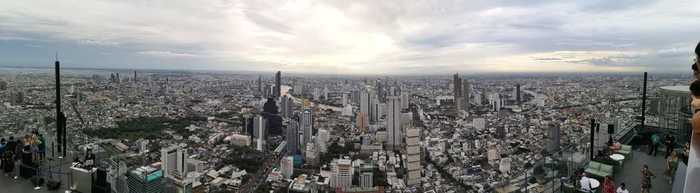 High angle view of modern buildings against cloudy sky