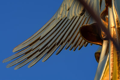 Low angle view of sculpture against clear blue sky