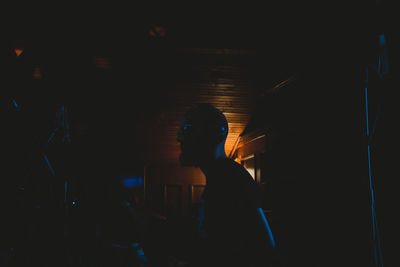 Man listening to music while sitting in darkroom