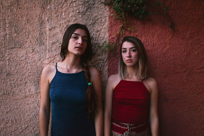 Portrait of lesbian couple standing against wall