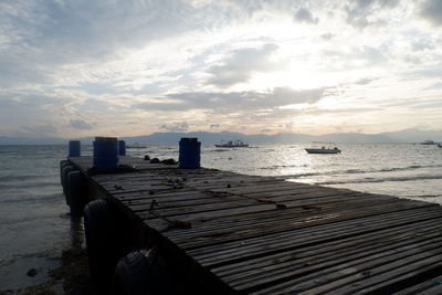 Pier over sea against sky during sunset