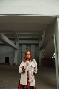 Young woman standing against wall