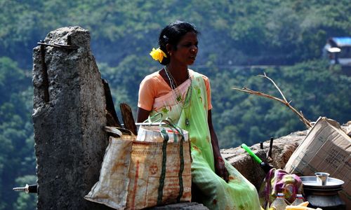 Woman standing by basket against trees