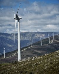 Wind turbines on land against sky