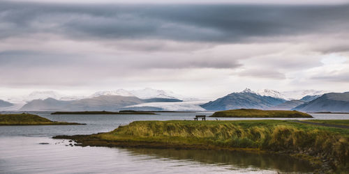 Scenic view of lake and mountains against sky