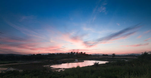 Scenic view of dramatic sky over silhouette trees during sunset