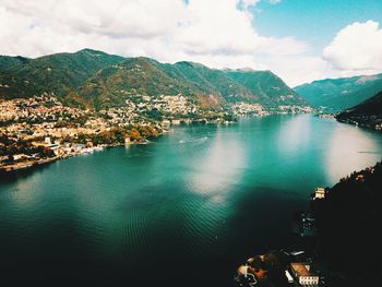 Aerial view of city by sea against sky