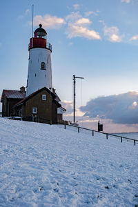 Tower on snow covered field against sky