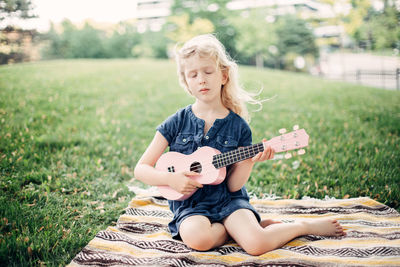 Cute girl sitting on field