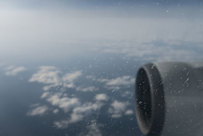 Close-up of wet airplane against sky