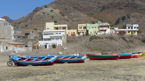 Boats moored on beach against sky