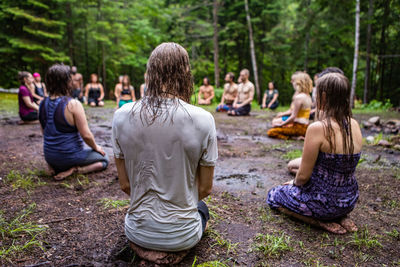 Rear view of people sitting on ground