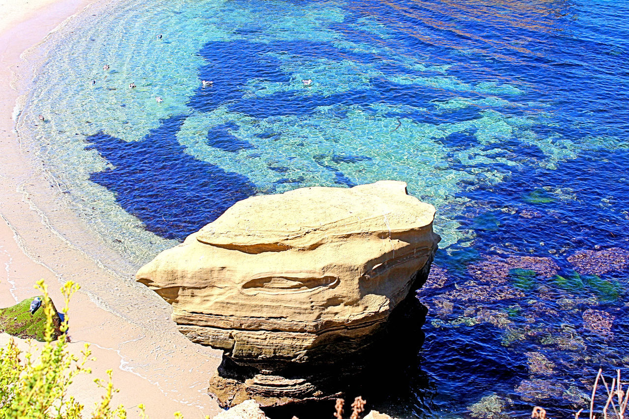 HIGH ANGLE VIEW OF ROCK FORMATION ON SEA SHORE