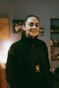Portrait of young woman standing at home